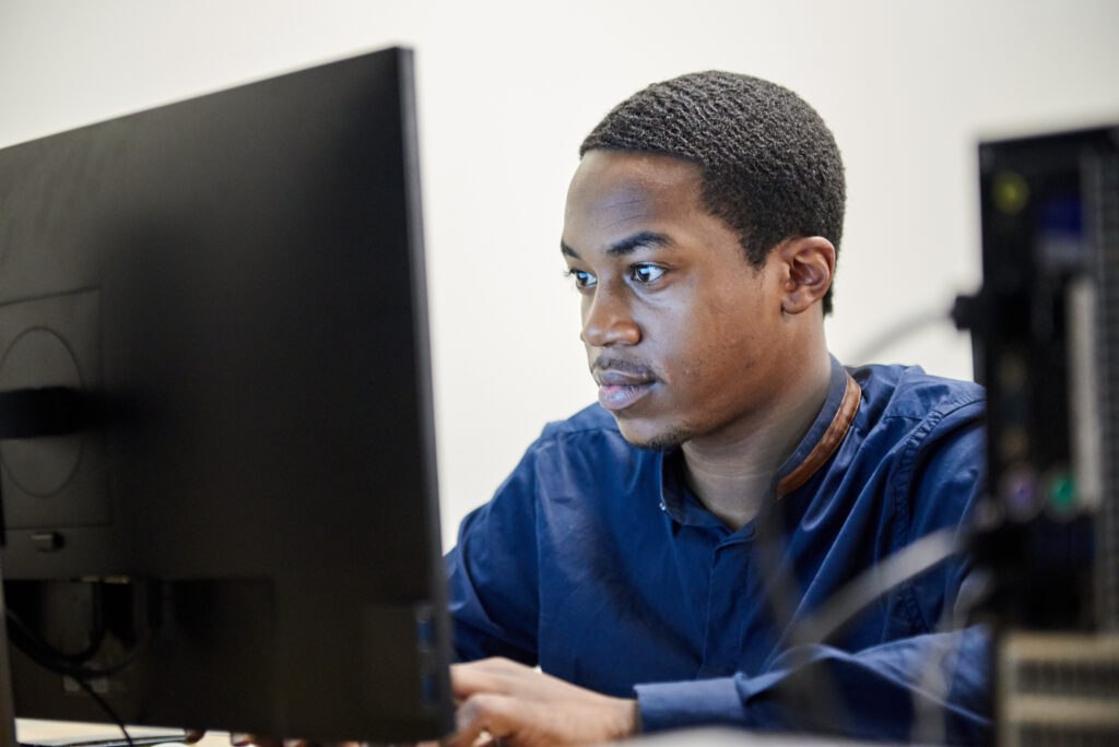 a black technologist stares at a computer screen