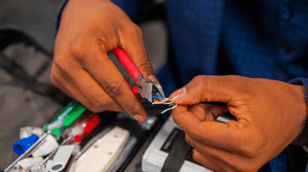 a pair of hands can be seen repairing a circuit board with tools