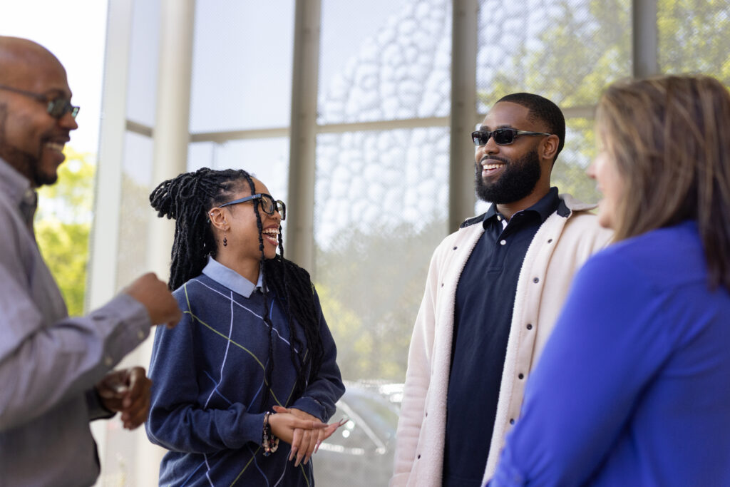 Four technical professionals smiling and talking outside