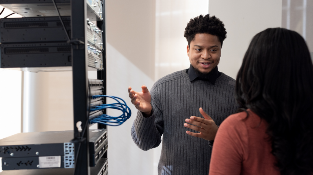 Instructor guiding participants through a live technical training session in front of a server rack