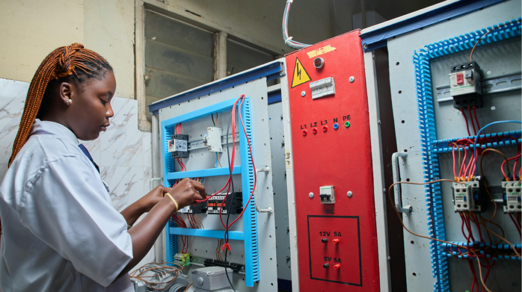 Female technician working on electrical control panel