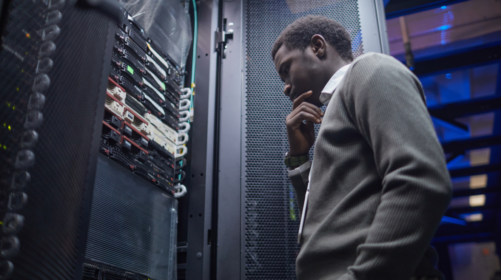 Data center engineer inspecting server hardware inside a rack in a live facility