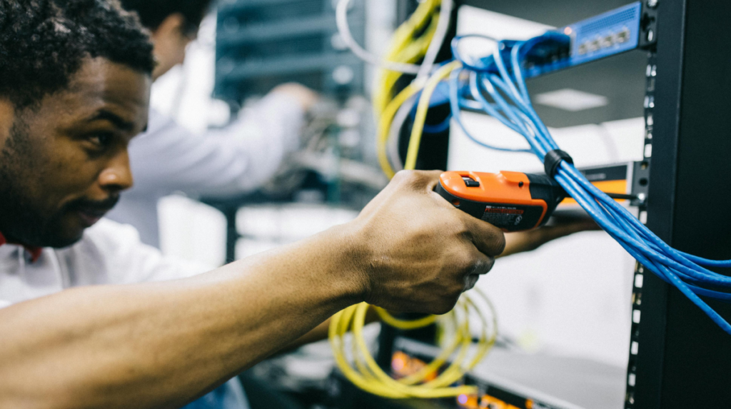 Technicians installing and managing structured cabling inside a server rack in a data center